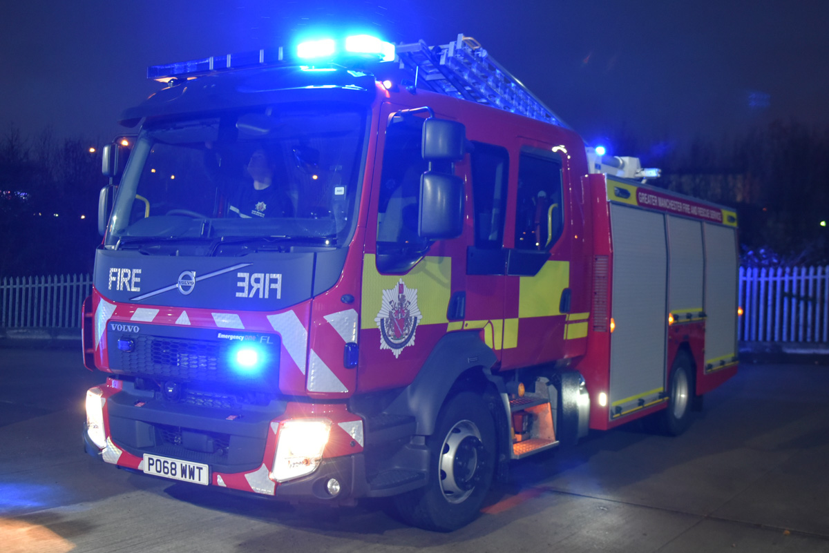 PO68WWT a Volvo FL fire engine parked in the yard of Ashton Fire Station with blue warning lights flashing